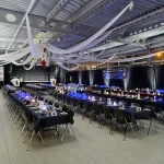 Licht-, Ton- und Videotechnik. Sichtschutz durch mobiles, selbststehendes Vorhangsystem (3.3m hoch, 32 Einheiten a 3.3m Länge). Lichtdeckoration mit 50 LED Schweinwerfern an der Inthronisation in der Emil Frey Halle in Ebikon Luzern 2019/2020/2021/2024